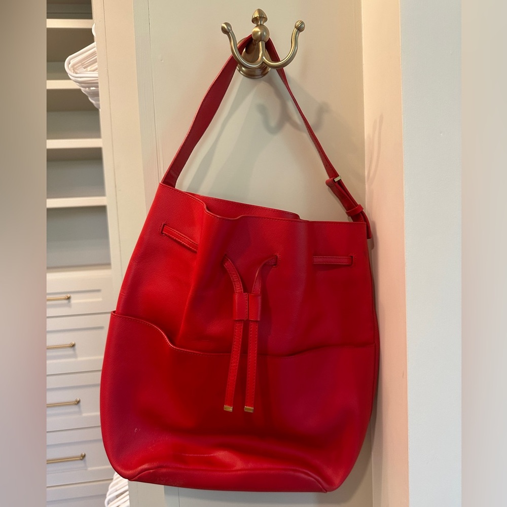 Cuyana red leather bucket bag with garment bag included.